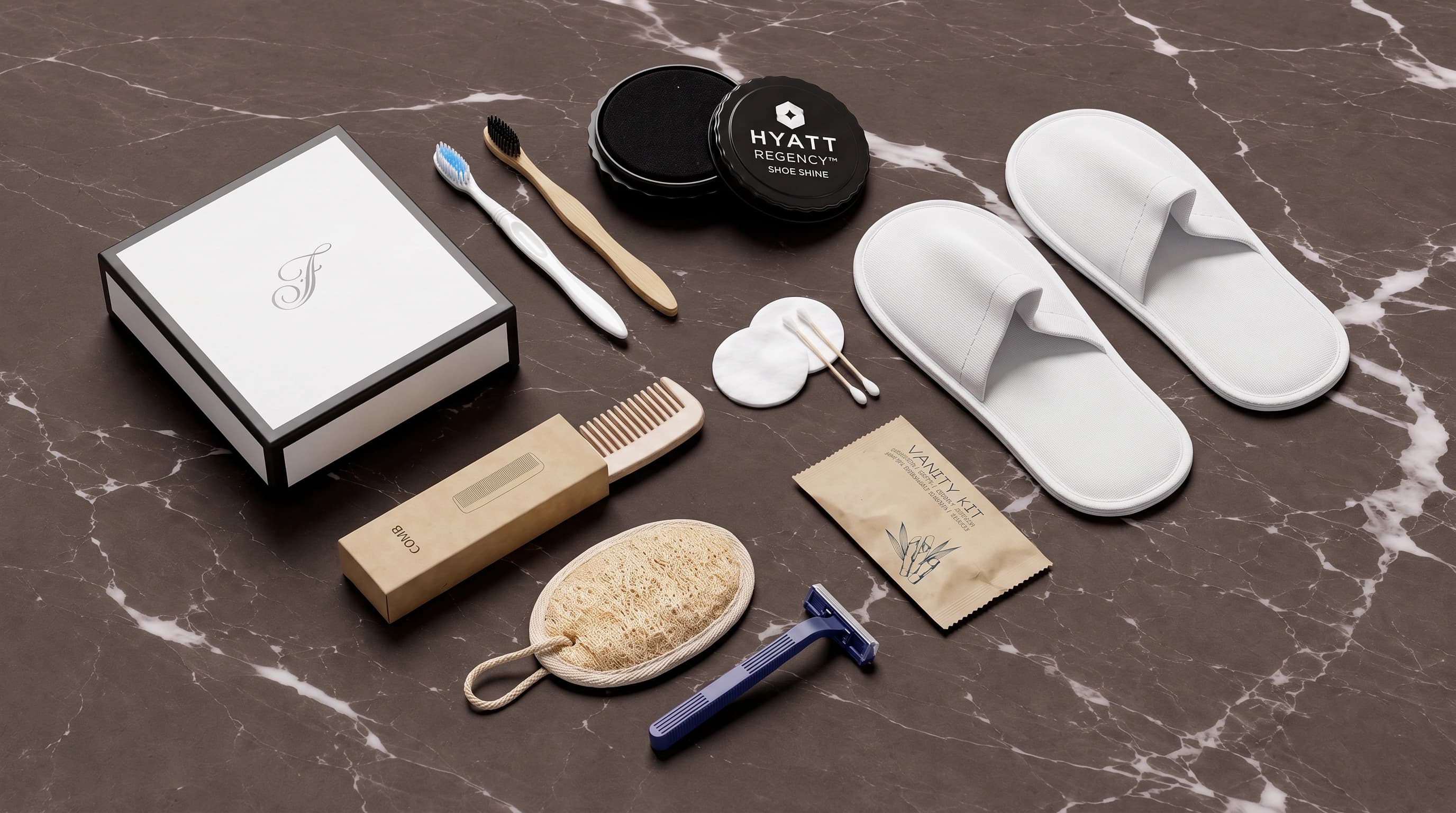 A hotel amenities set — slippers, bamboo and classic toothbrushes, comb, loofah, razor, shoe shine and vanity kit — arranged on dark marble